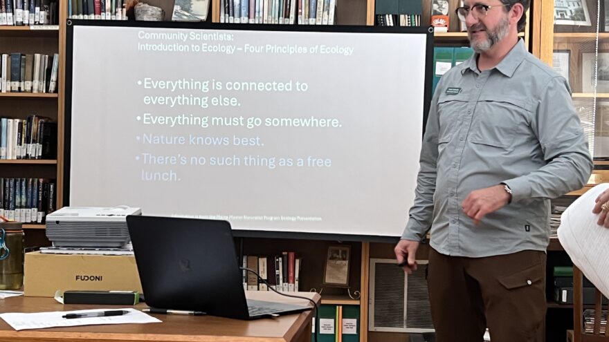 Man in library giving presentation
